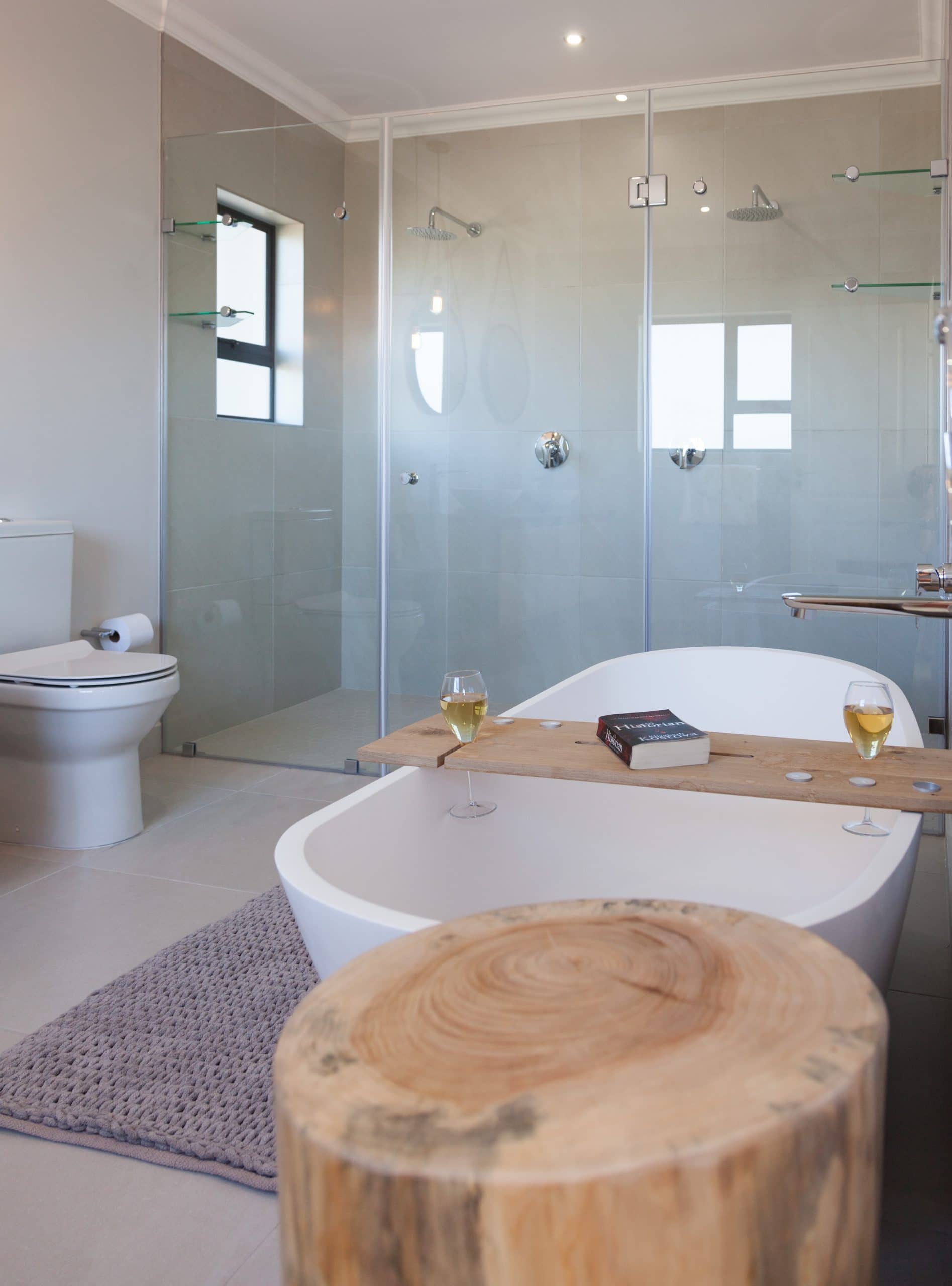 modern warm bathroom with wood bath holder wine and book
