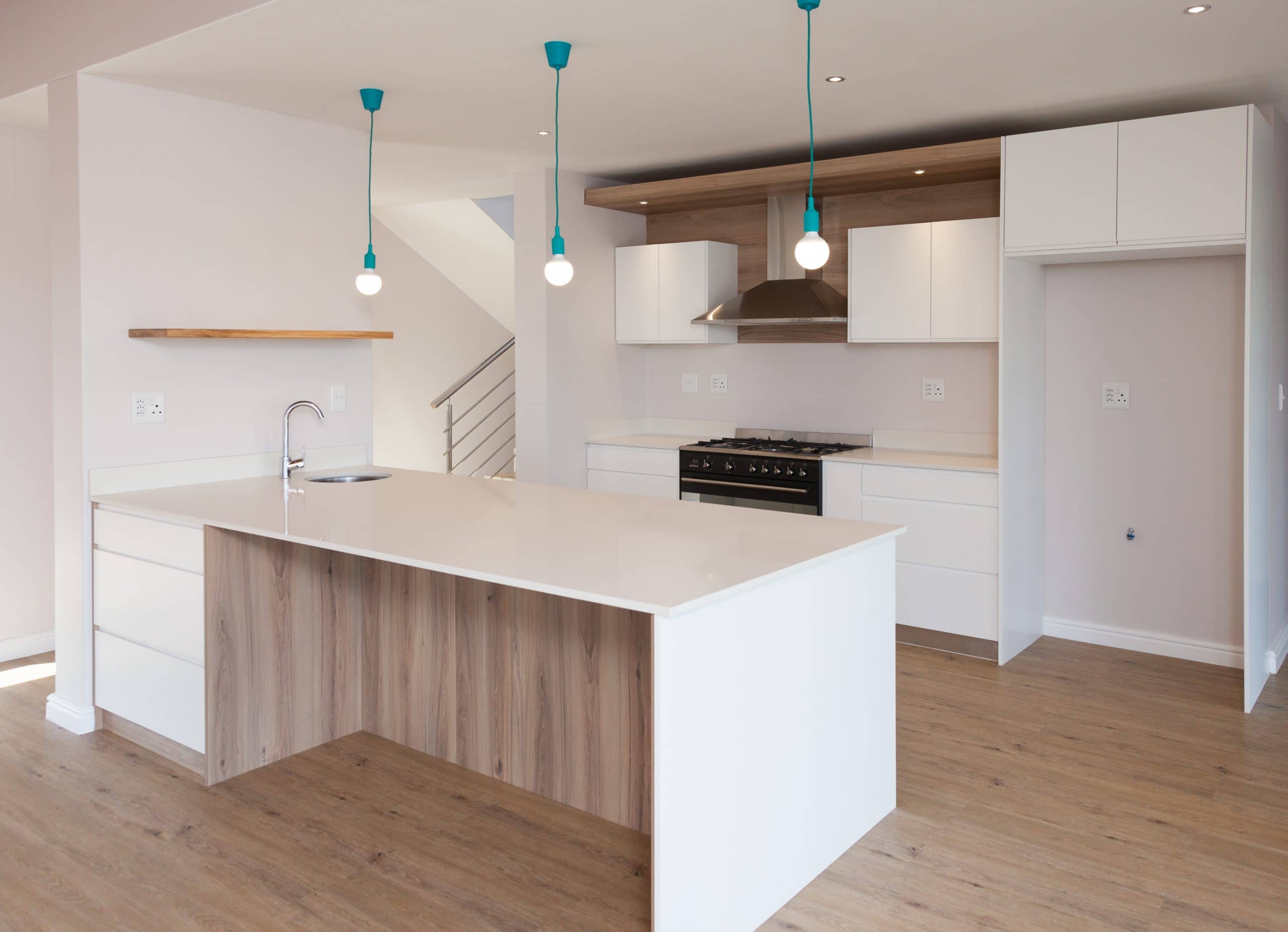 white and ebony wood kitchen with blue pendants and smeg appliances
